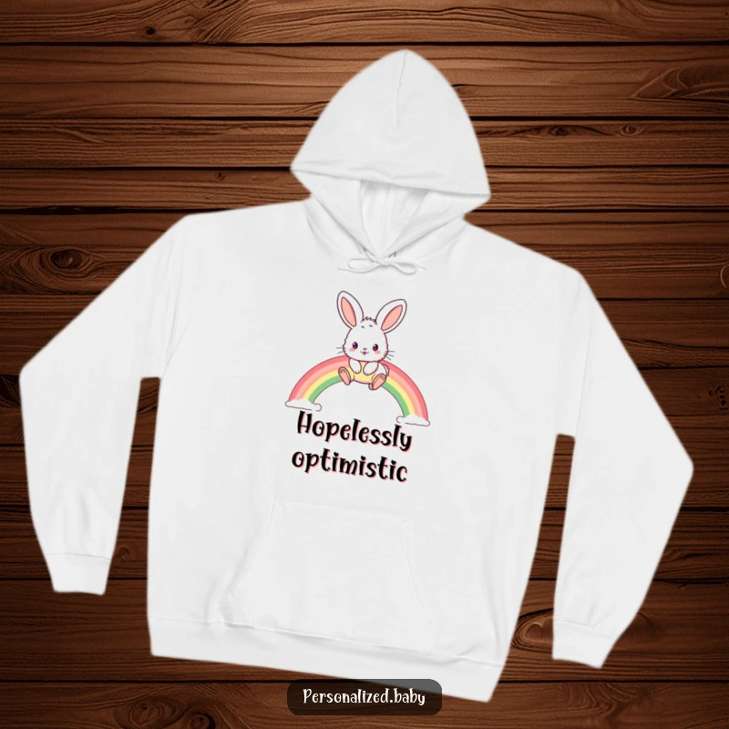 Funny hoodie displaying a fluffy bunny with enormous ears joyously leaping across a vivid, arched rainbow.