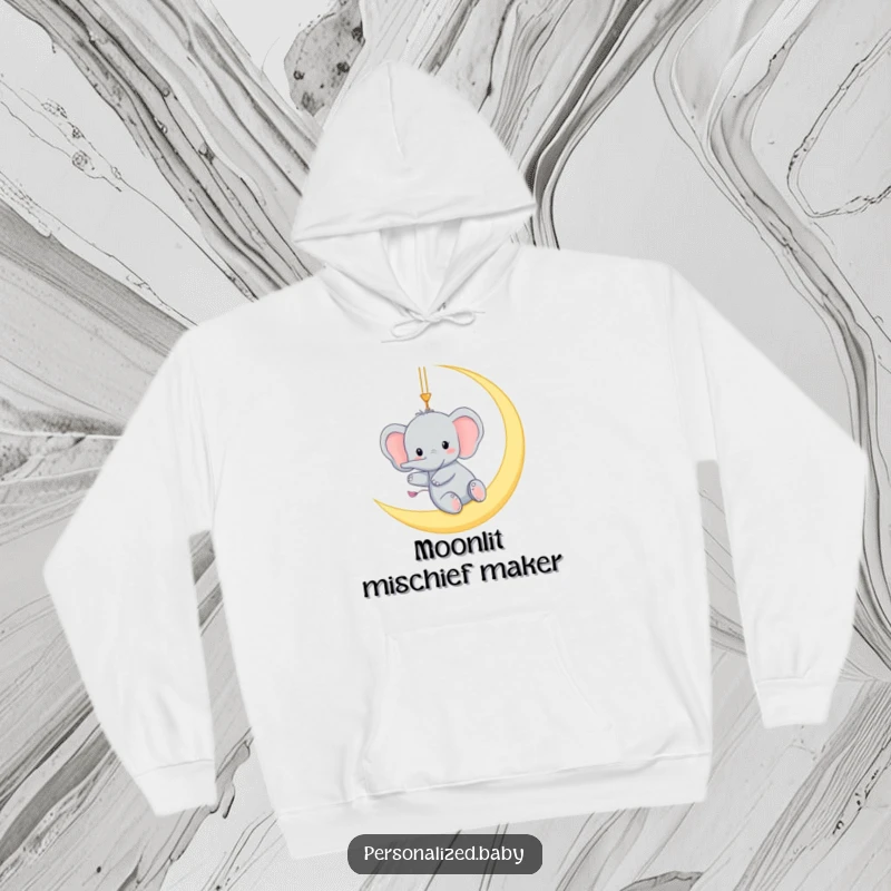 Funny hoodie with a tiny elephant gleefully swinging from a crescent moon, offering warm, humorous, and magical comfort.